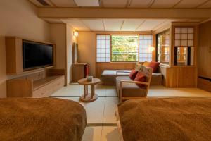 a living room with a couch and a tv at yukairouKikuya in Izu