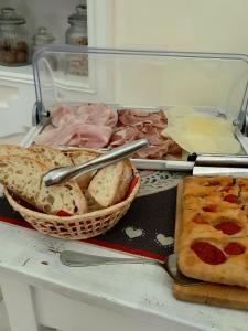 a table with a basket of bread and a pizza at Aedes B&B Il Giardino dei Sogni in Lecce