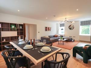 Una sala de estar con una mesa y sillas y un sofá. en The Violet Suite Stone Cross Mansion, en Ulverston