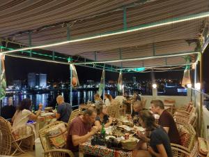 a group of people sitting at tables at a restaurant at Bob Marley Guest House in Aswan