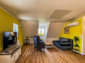 a living room with a couch and a tv at Altwernigeröder Apparthotel in Wernigerode