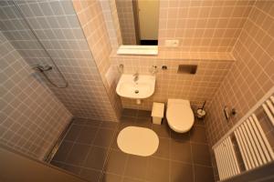 a bathroom with a white toilet and a sink at Hotel Harfa in Prague