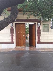 a pair of wooden doors in a brick building at Marhabo Guesthouse in Samarkand