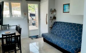 a living room with a blue couch and a table at Maisonnette bois flottés in Salles