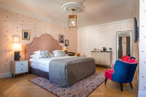 a bedroom with a large bed and a blue chair at Hotel Capital in Zagreb