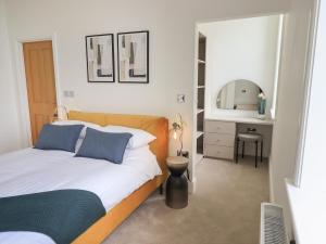 a bedroom with a bed and a vanity with a mirror at The Alfred Suite Stone Cross Mansion in Ulverston
