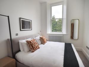- un lit blanc dans une chambre avec fenêtre dans l'établissement The Kathleen Suite Stone Cross Mansion, à Ulverston
