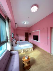 a pink bedroom with a bed and a couch at 2H-share home in Yuchi