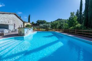 a swimming pool with blue water in front of a house at Agriturismo I Pietrini in Perugia