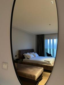sypialnia z łóżkiem i lustrem w obiekcie Grand Mirage we Wlorze