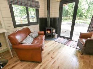 a living room with a leather couch and a fireplace at Lake View Lodge in Scarborough