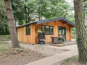 a tiny house in the woods with a table and chairs at Lake View Lodge in Scarborough