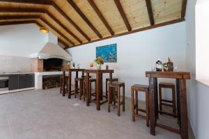 eine Küche mit Holztischen und Hockern in einem Zimmer in der Unterkunft Residence Ellena in Zadar