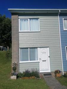 a gray house with a white door and windows at Le Chalet - 2 Bedroom Chalet House sleeps 3 in Pembrokeshire