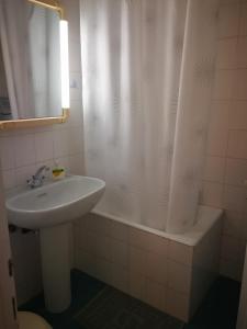 a bathroom with a sink and a shower curtain at Jenny's luxury flat near the center & Beach in Kalamata +8 photos