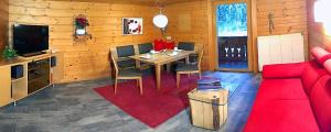 - un salon avec une table et un canapé rouge dans l'établissement Ferienwohnung Winkler, à Silbertal