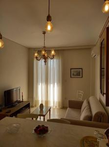 a living room with a couch and a chandelier at Jenny's luxury flat near the center & Beach in Kalamata