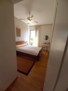 a bedroom with a bed and a ceiling fan at Jenny's luxury flat near the center & Beach in Kalamata