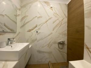 Baño blanco con lavabo y espejo en Hotel Filoxenia, en Neoi Poroi