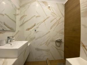uma casa de banho branca com um lavatório e um espelho em Hotel Filoxenia em Neoi Poroi