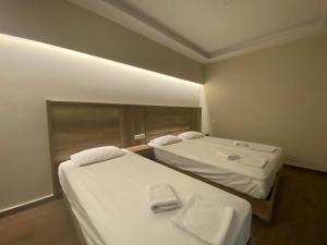 Dos camas en una habitación de hotel con toallas. en Hotel Filoxenia, en Neoi Poroi