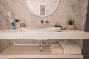 ein Badezimmer mit einem weißen Waschbecken und einem Spiegel in der Unterkunft Grand Mirage in Vlorë