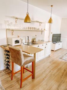 a kitchen with a wooden table and a microwave at Apartmán Opera Prosecco Bar in Banská Štiavnica