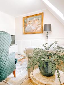 a living room with a couch and a table with a plant at Apartmán Opera Prosecco Bar in Banská Štiavnica