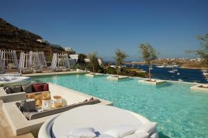 ośrodek z basenem z krzesłami i wodą w obiekcie Once in Mykonos - Designed for Adults w mieście Ornos