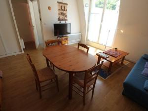 uma sala de estar com uma mesa de madeira e cadeiras em Appartement Bagnères-de-Luchon, 2 pièces, 4 personnes - FR-1-313-135 em Luchon