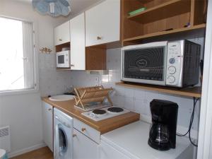 uma pequena cozinha com um micro-ondas e um fogão em Appartement Bagnères-de-Luchon, 2 pièces, 4 personnes - FR-1-313-135 em Luchon