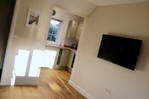 Lawnside 1 في بودليغ سالترتون: غرفة معيشة مع تلفزيون بشاشة مسطحة على جدار