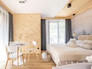sypialnia z łóżkiem, stołem i krzesłami w obiekcie Apartamenty Klemensówka w Zakopanem