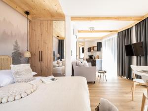 a bedroom with a bed and a living room at Apartamenty Klemensówka in Zakopane