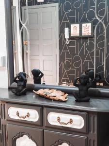 a dresser with black figurines on it in front of a mirror at Vivienda turística Mou in Arzúa