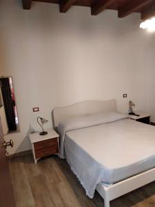 Ai doganieri في رانداتسو: غرفة نوم مع سرير أبيض و منضدة و sidx سرير