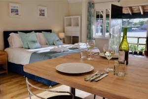 Habitación con cama y mesa con copas de vino en Lawnside 2, en Budleigh Salterton