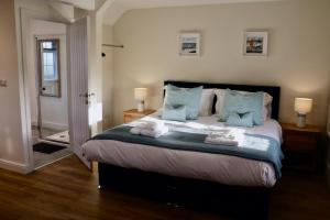 a bedroom with a large bed with blue pillows at Lawnside 2 in Budleigh Salterton