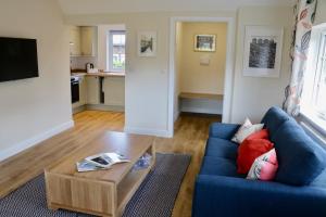 a living room with a blue couch and a coffee table at Lawnside 3 in Budleigh Salterton