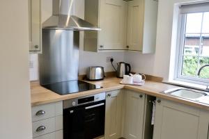 a kitchen with a stove top oven next to a window at Lawnside 3 in Budleigh Salterton