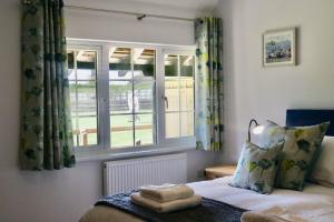a bedroom with a bed and a window at Lawnside 3 in Budleigh Salterton