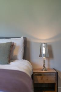 a lamp on a night stand next to a bed at Rose Cottage, Eden Valley, Cumbria in Cumwhitton