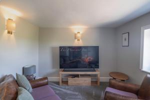 a living room with a flat screen tv on the wall at Rose Cottage, Eden Valley, Cumbria in Cumwhitton