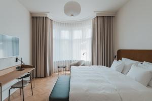 a bedroom with a large white bed and a desk at Solo Sokos Hotel Torni Helsinki in Helsinki