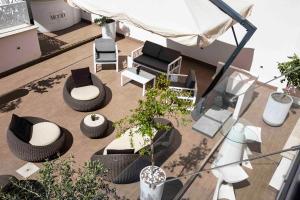 a patio area with chairs, tables and umbrellas at Rome Life Hotel in Rome