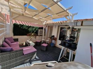 an outdoor patio with awning and chairs and tables at Appartamento nella piazza centrale, con terrazza in SantʼAntìoco