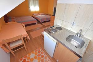 a small kitchen and living room with a sink and a table at Apartments Kujacic in Herceg-Novi +32 photos