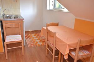 a small kitchen with a table and a sink at Apartments Kujacic in Herceg-Novi