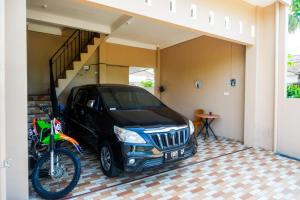 a car parked in a garage next to a bike at RedDoorz Syariah near Stasiun Gumilir Cilacap in Gumilir