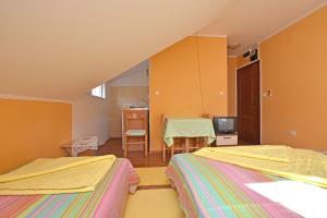 a room with two beds and a table with a television at Apartments Kujacic in Herceg-Novi